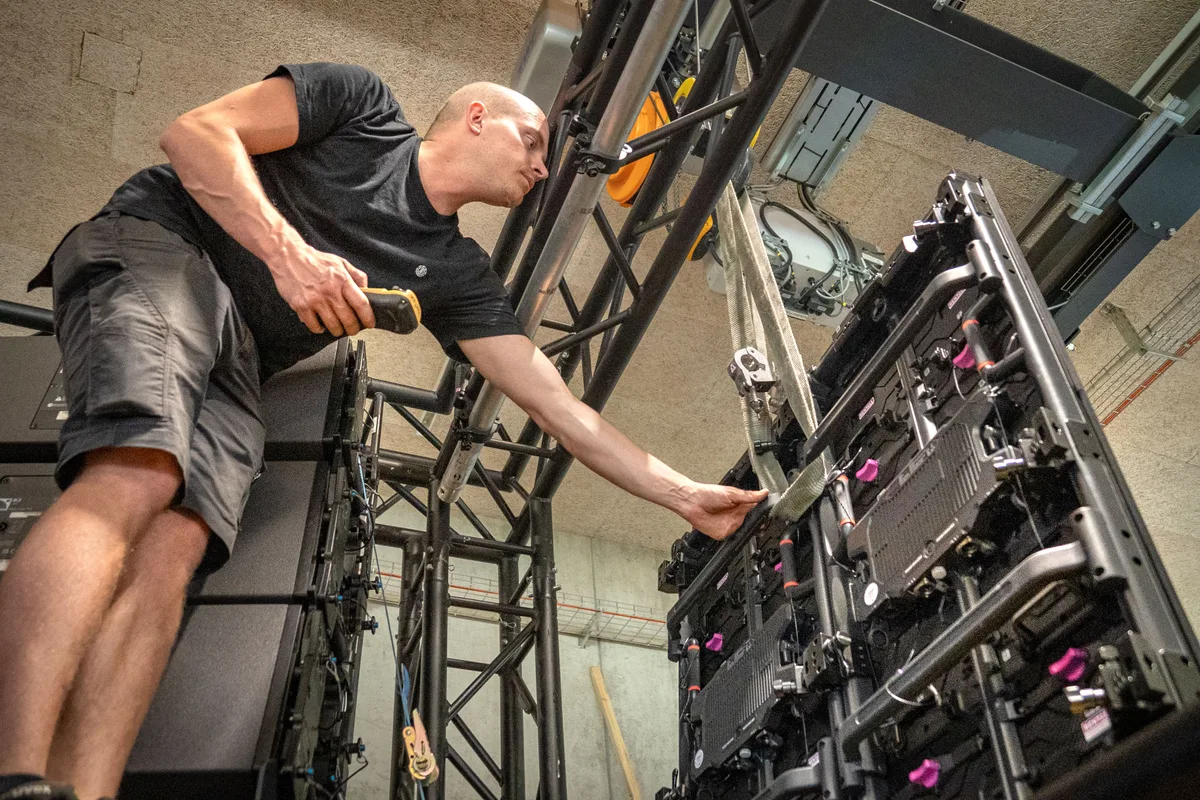 Der Techniker Lars Klotzek installiert die Screens.